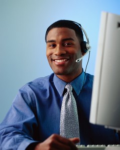 Businessman Wearing a Phone Headset at a Computer